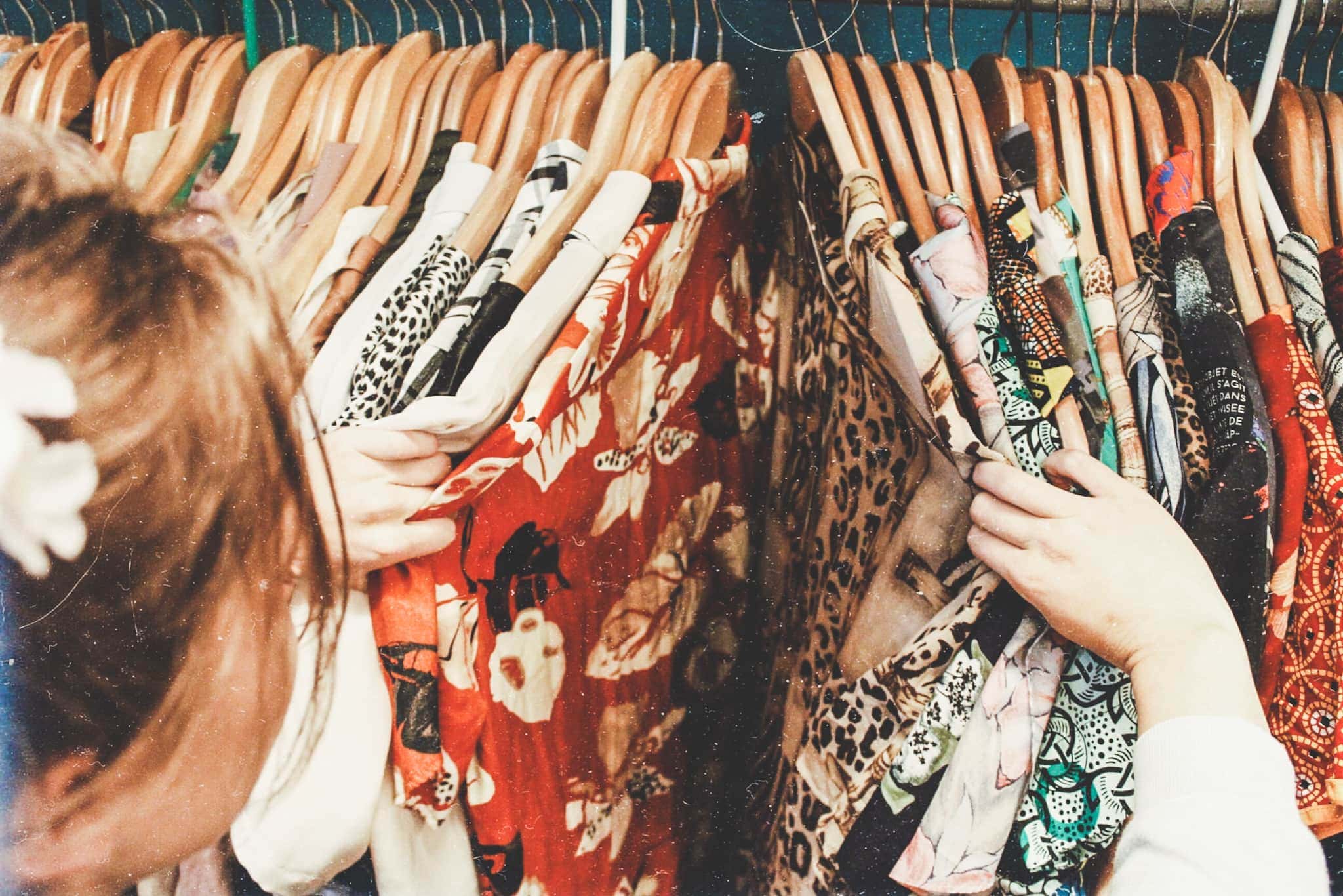 woman searching secondhand clothing rack