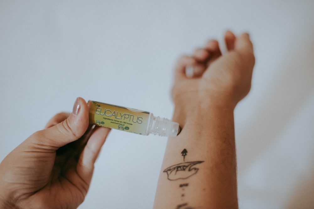 person applying eucalyptus essential oil roller