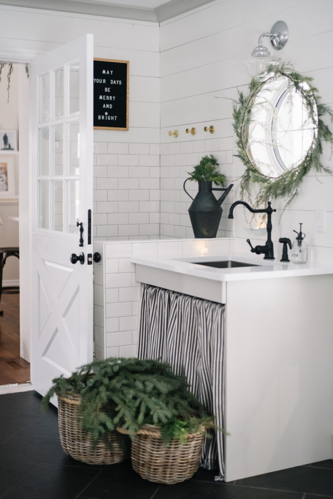 minimal bathroom with evergreen garland around mirror