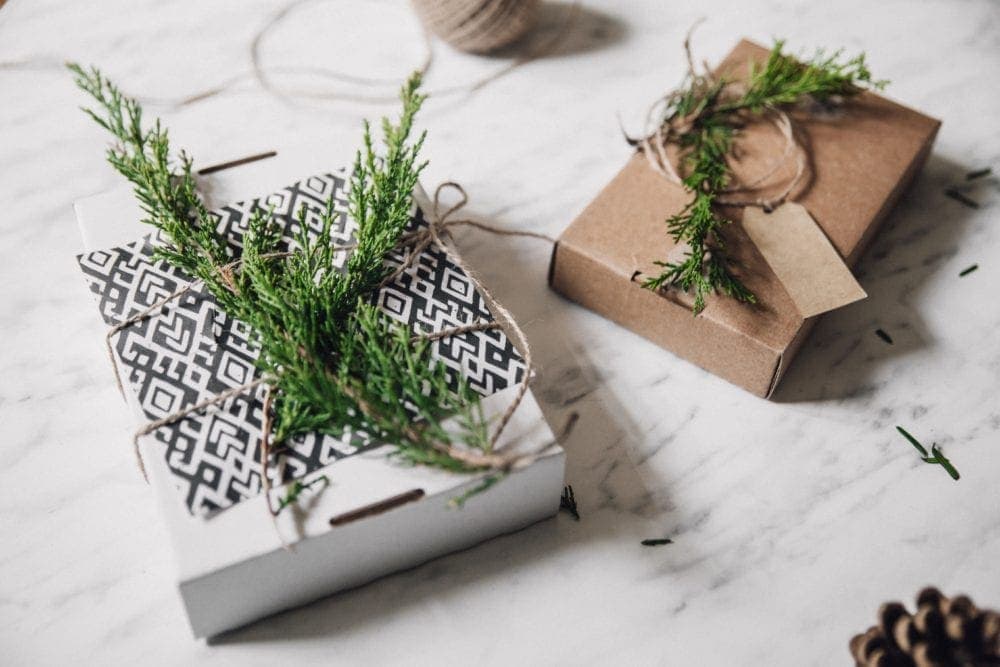 gifts inside repurposed cardboard boxes with twine and tree branches