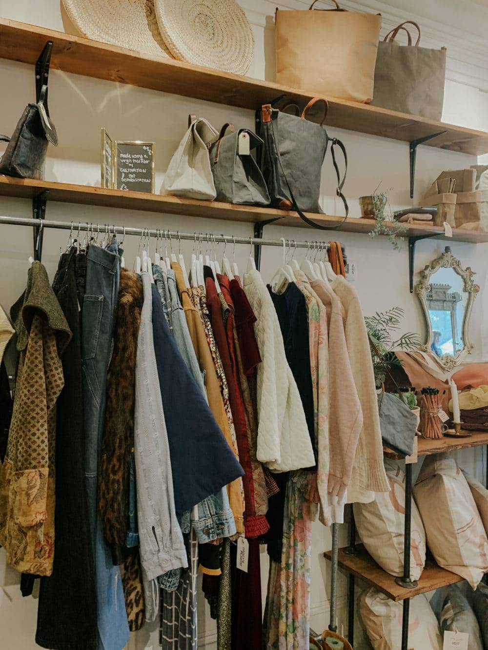 secondhand clothing hanging on rack in thrift store