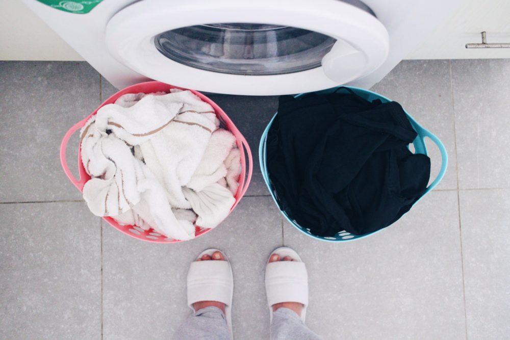 two sorted laundry baskets filled with sorted white and dark fabrics