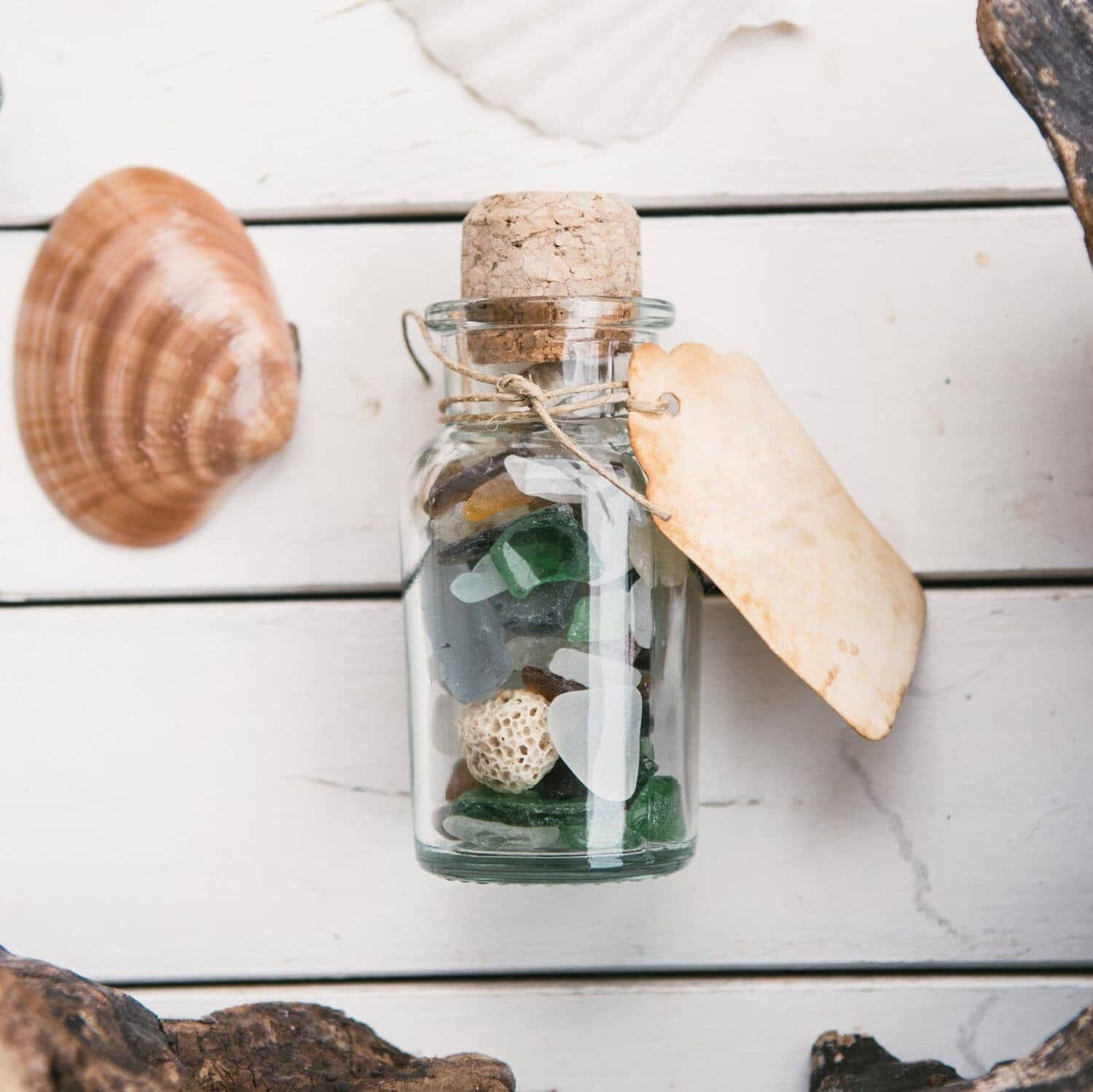 glass jar filled with sea glass with cover and tag