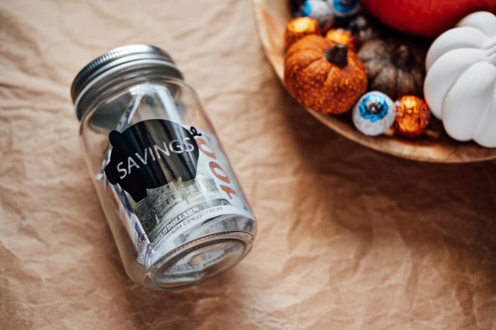 repurposed glass jar with savings label and paper money inside