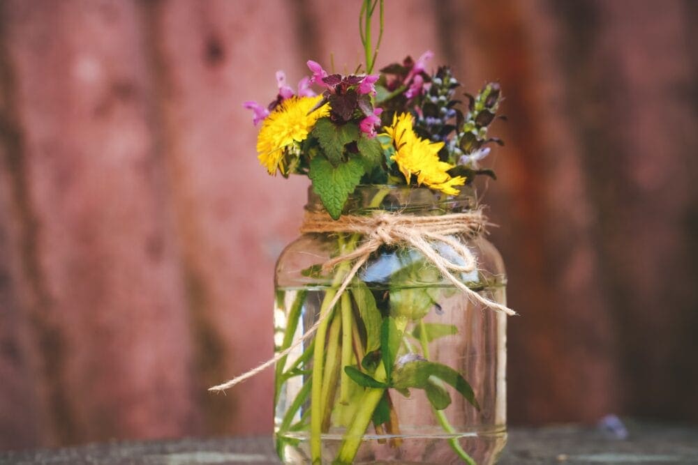 glass jar vase with water and flowers 