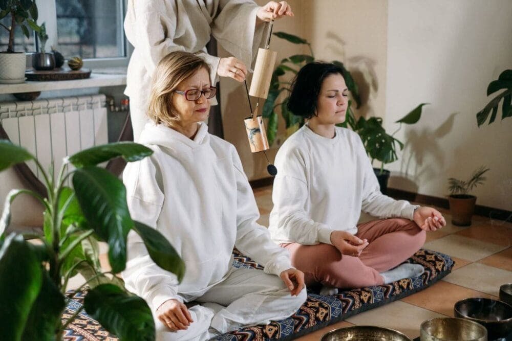 two women meditating no floor with instructor