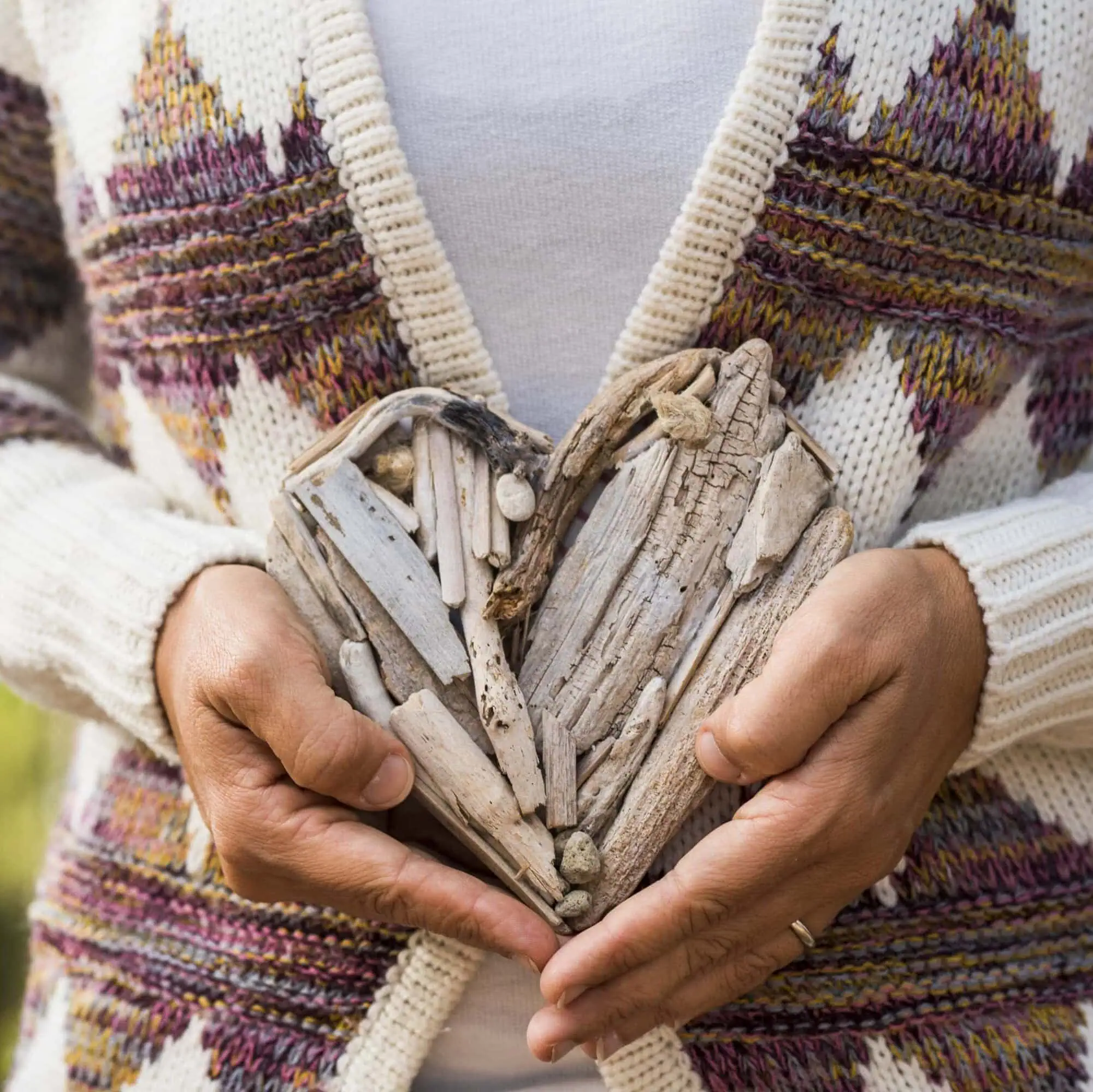 woman holding DIY driftwood heart decoration