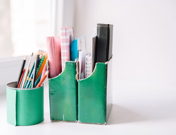 repurposed cardboard box and tin can organizers with supplies inside