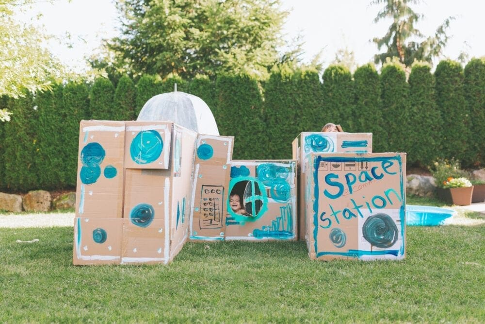 cardboard boxes repurposed into a space station play toy for kids
