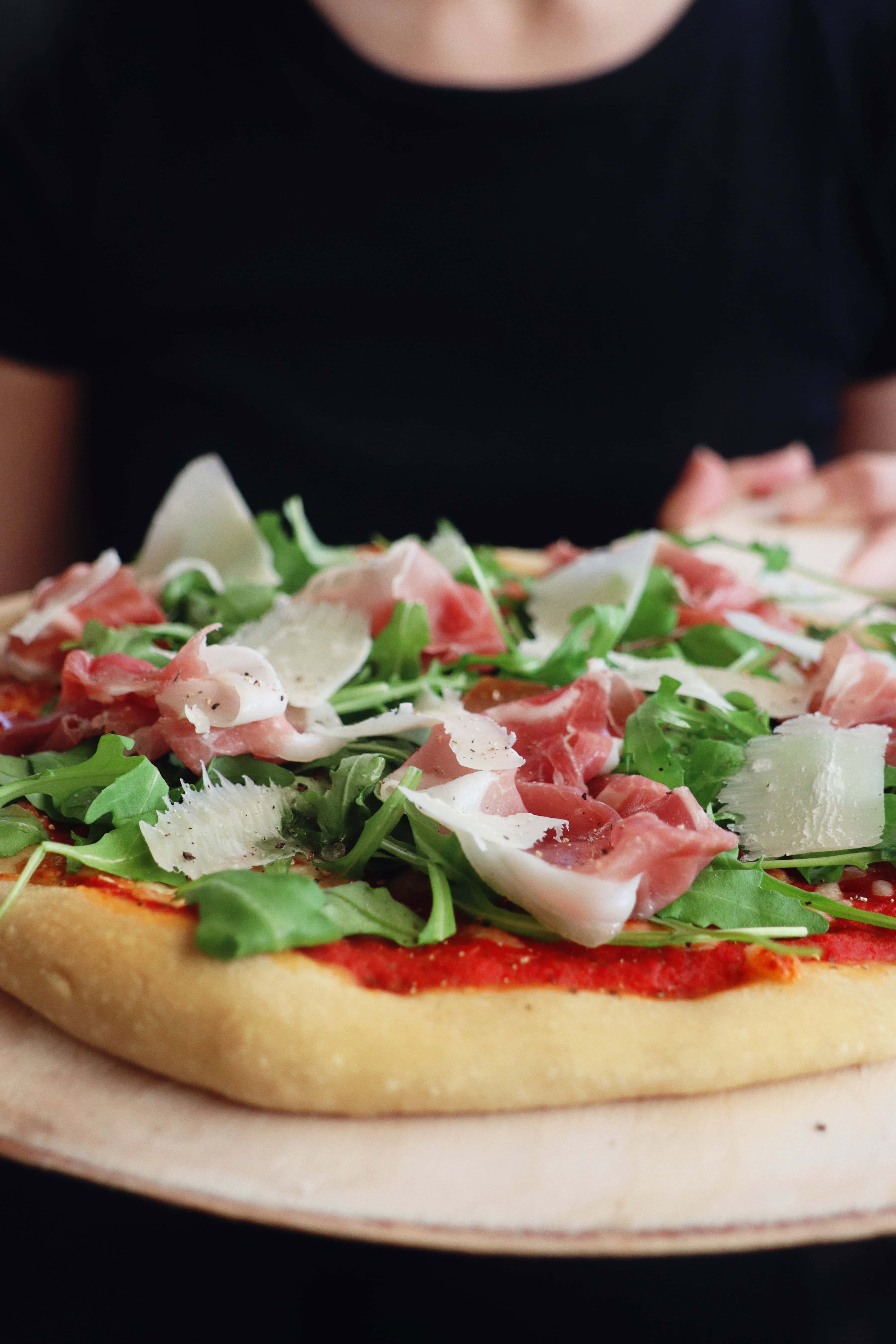 Crisp pizza with parma ham, parmesan and rucola