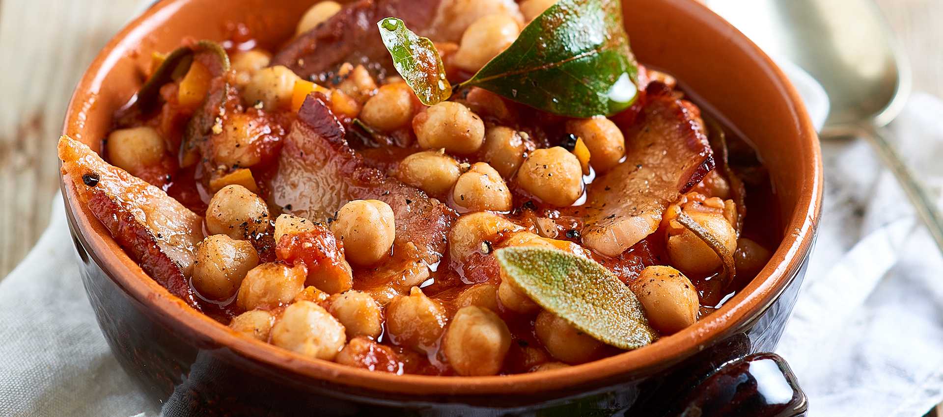 Erbsen-eintopf mit geschälten tomaten und speck