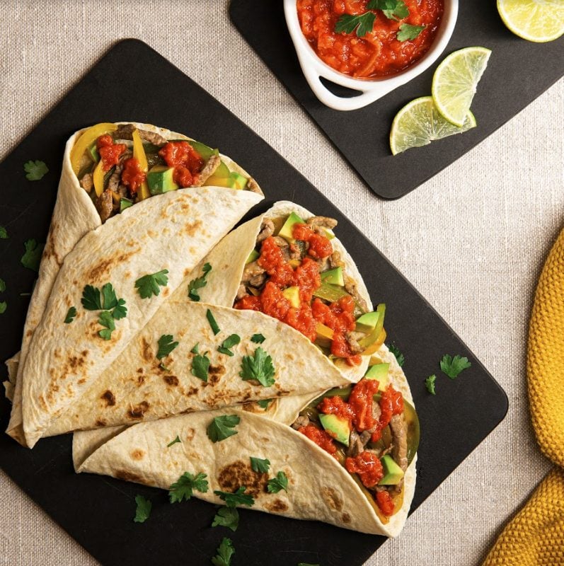 Fajitas mit rindfleisch, avocado, tomate und limette