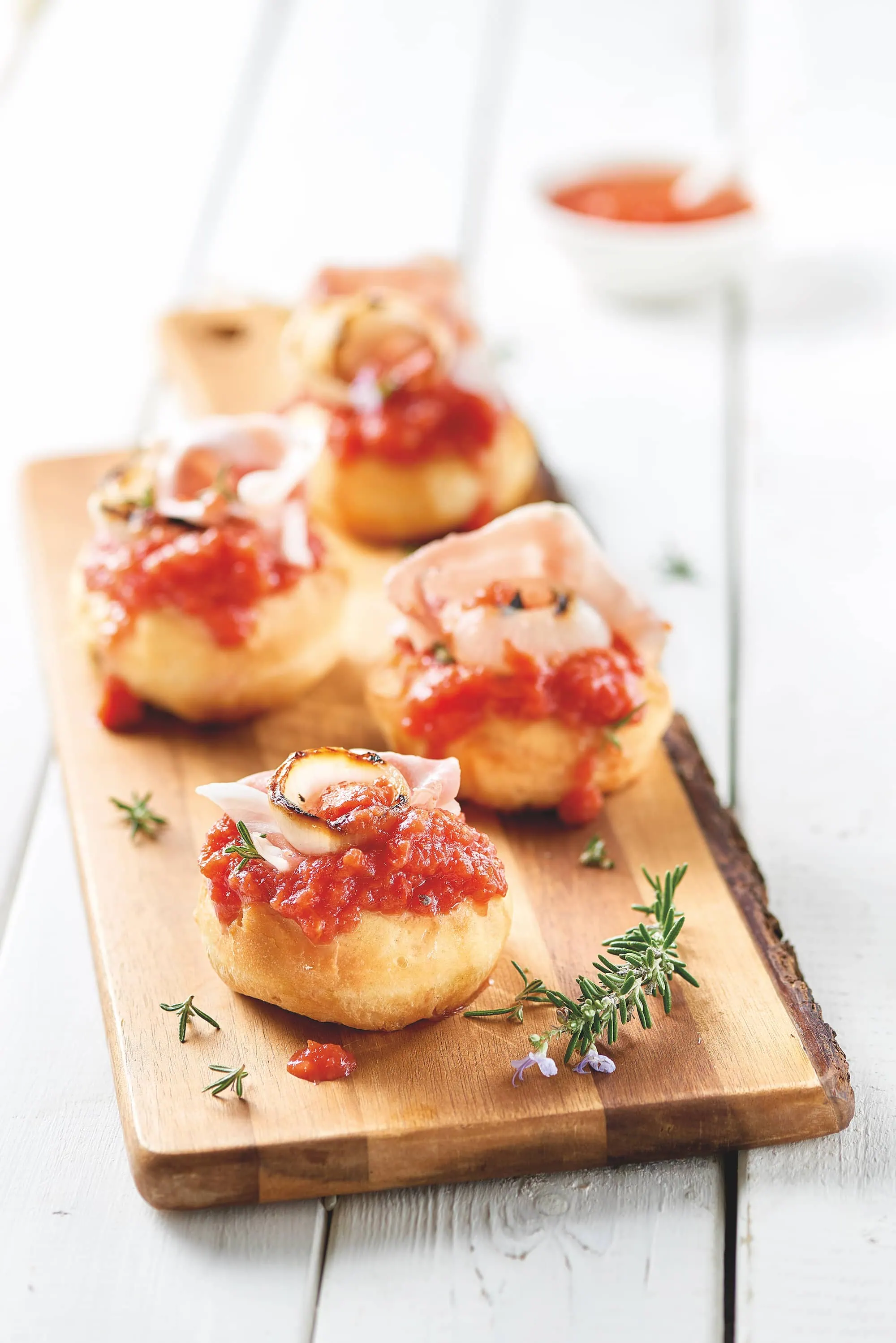 Mini pizzas à la tomate, oignons grillés et bacon