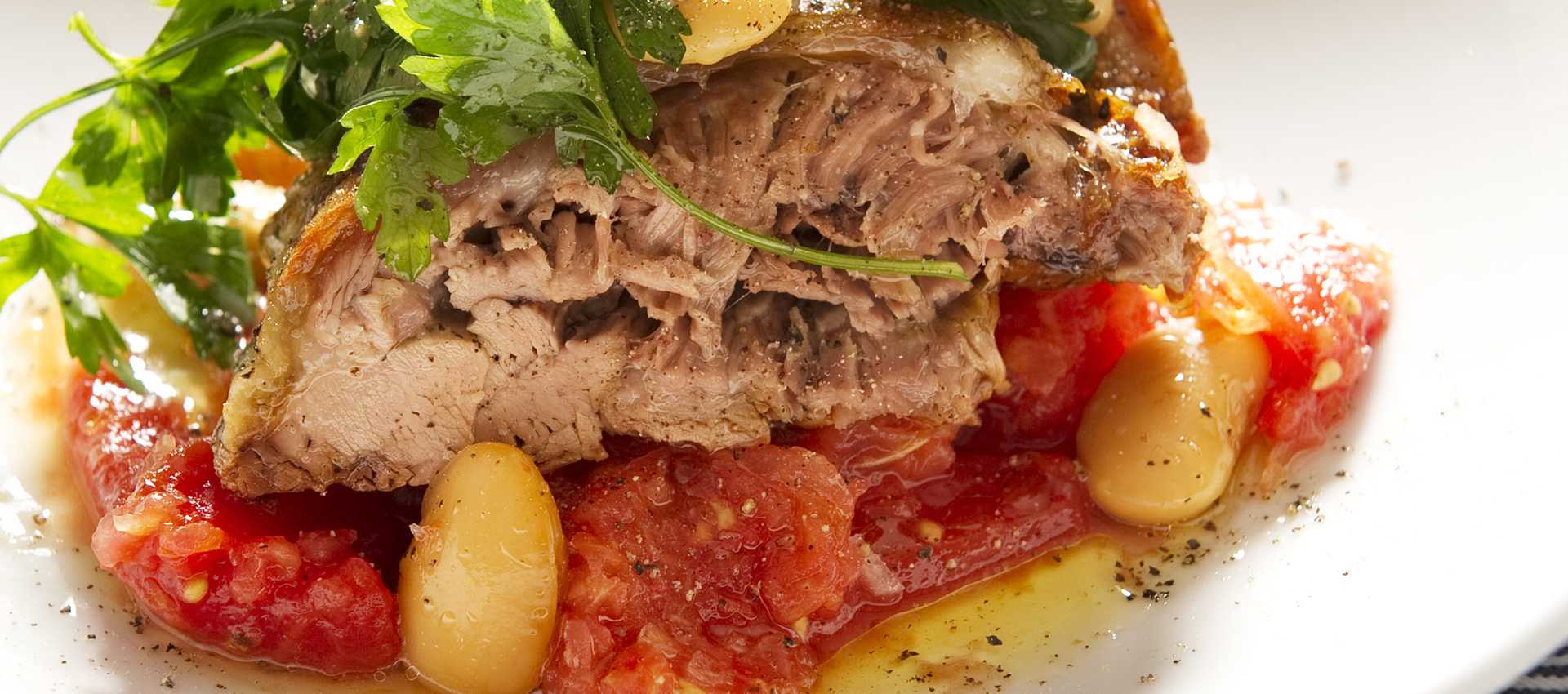 Gigot d’agneau tendre aux tomates, au persil et aux haricots blancs