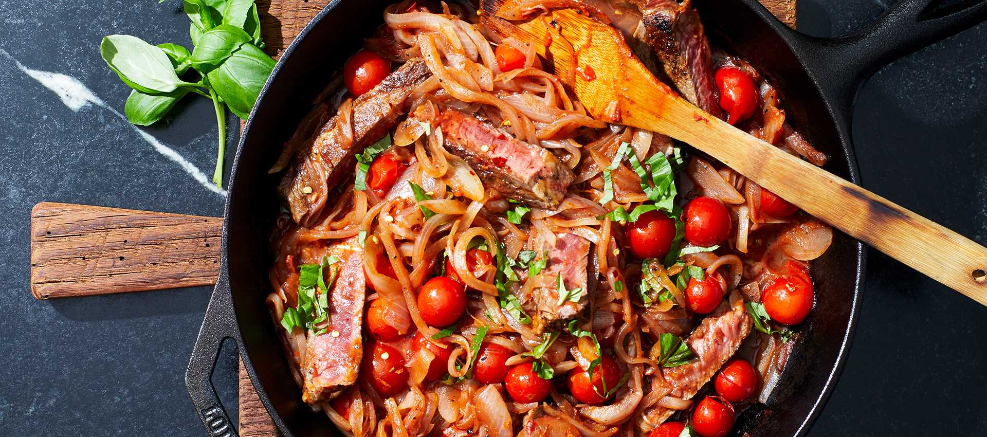 Pan seared steaks with tomatoes and onions