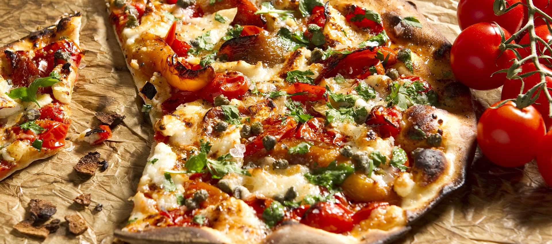Pizza z pomidorami, kozim serem, papryką, kaparami i ziołami