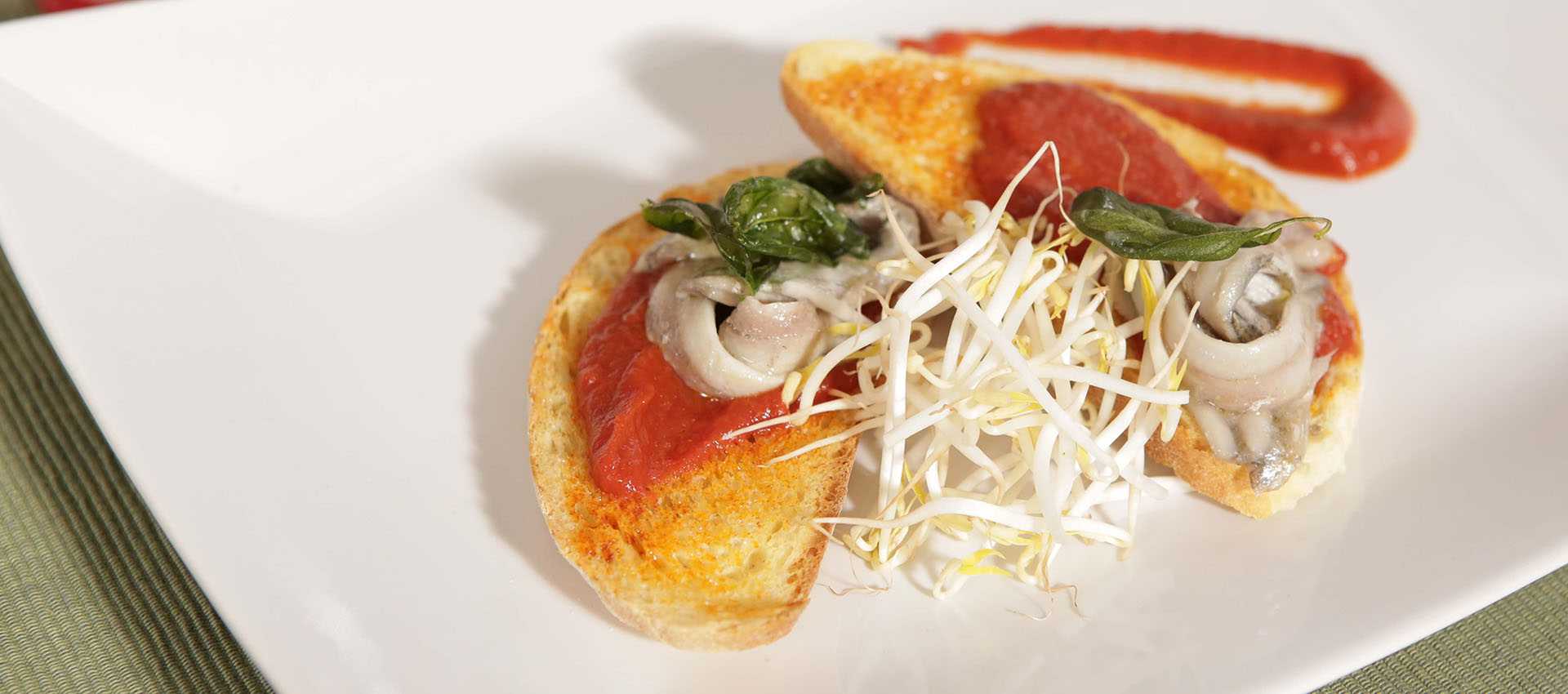 Bruschetta met gemarineerde ansjovis en een pittige rode saus