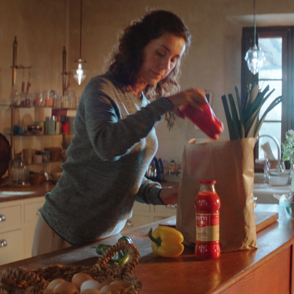 donna cucina con polpa di pomodoro mutti