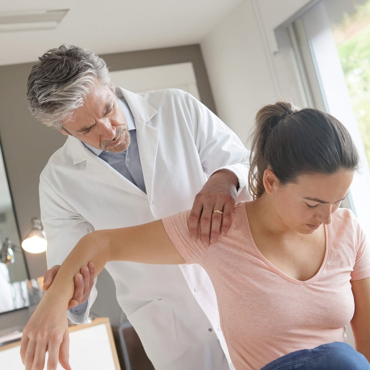 Doctor examining shoulder injury.