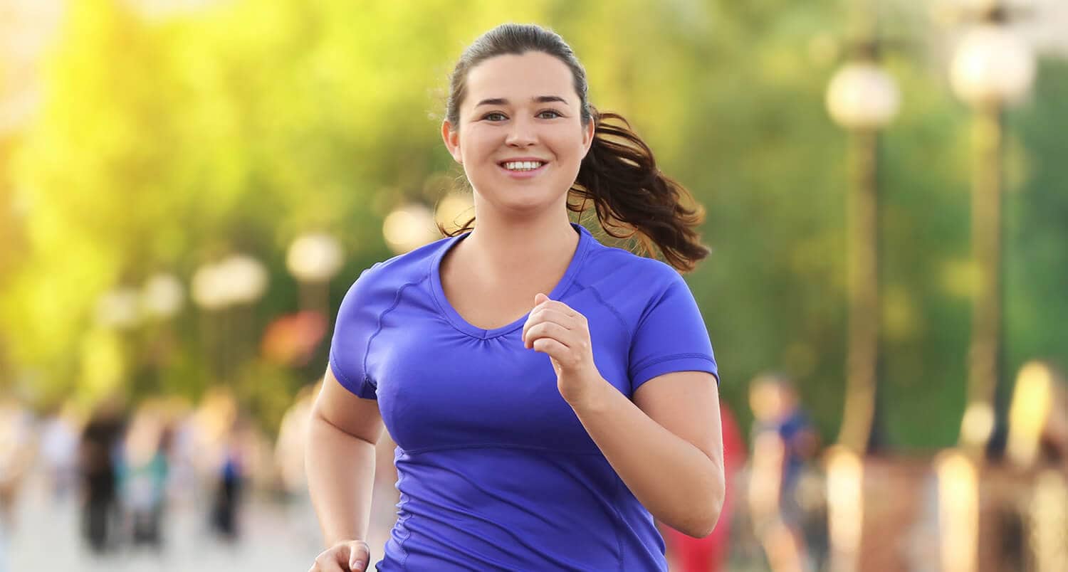 Woman jogging outdoors during daylight for orthopedic rehabilitation