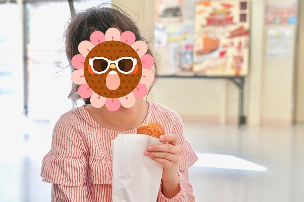 娘がその場で歩のサーターアンダギーを食べる様子