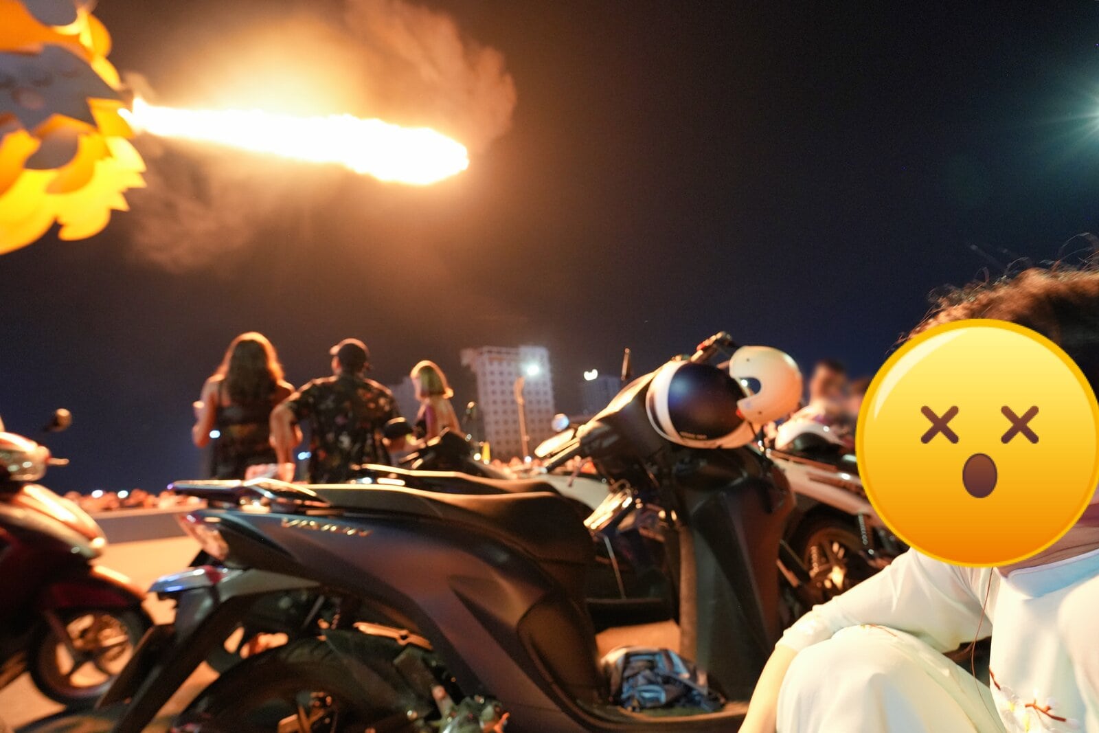 夜空に打ち上げられる花火と、バイクや人々が集まる賑やかなシーンを捉えた夜のイベント写真.