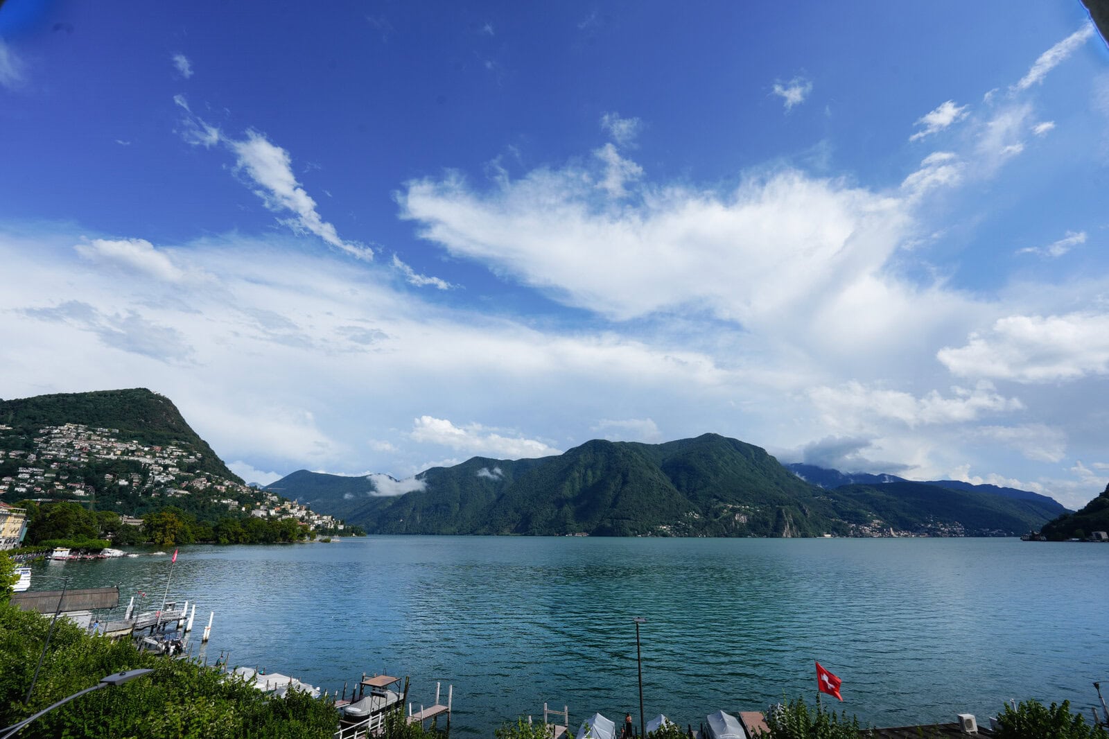 部屋の窓から見えるルガーノ湖と山の景色