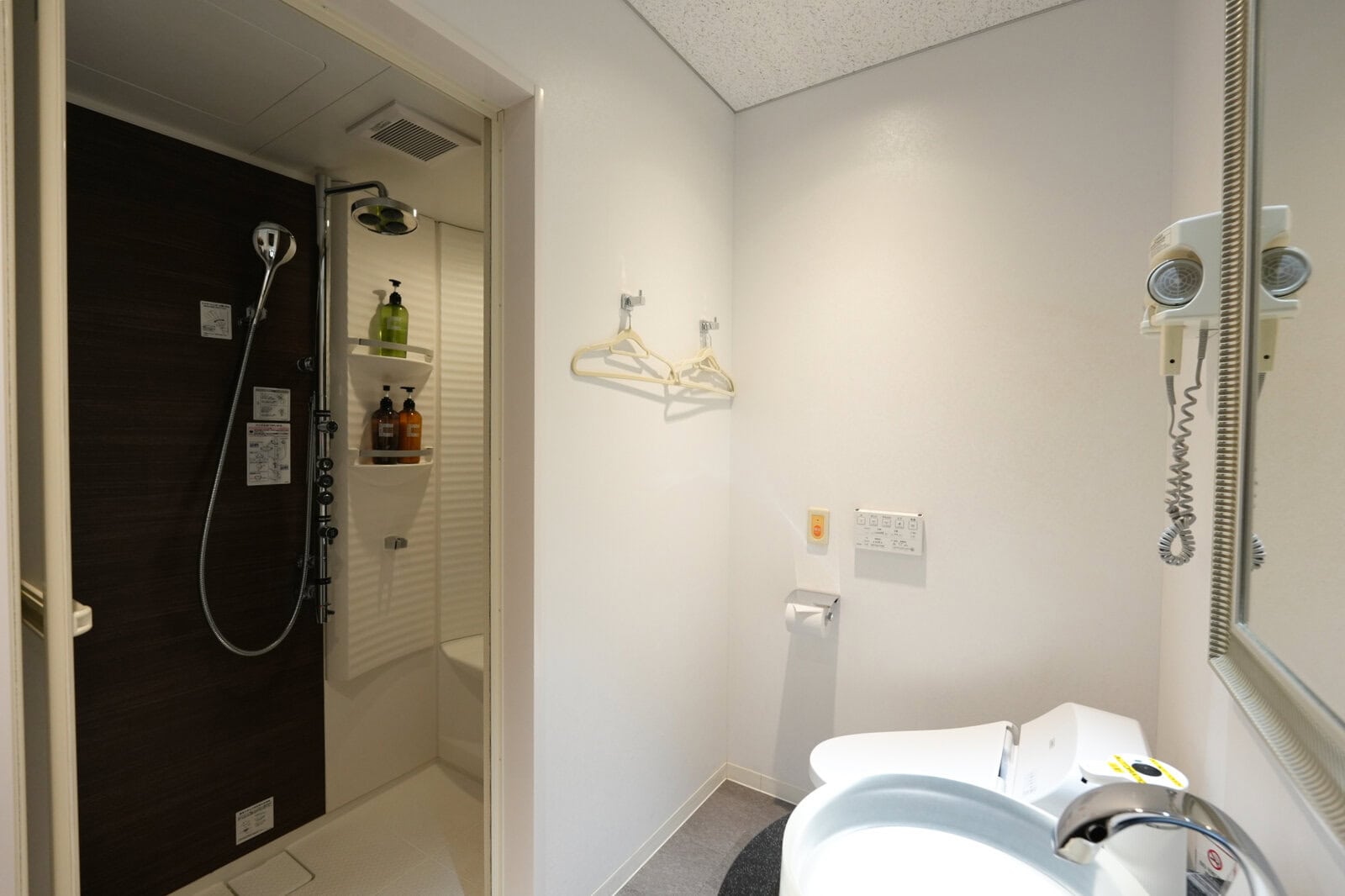 NARITA PREMIER LOUNGEのレインシャワー、トイレ、ドライヤーを備えたシャワールーム