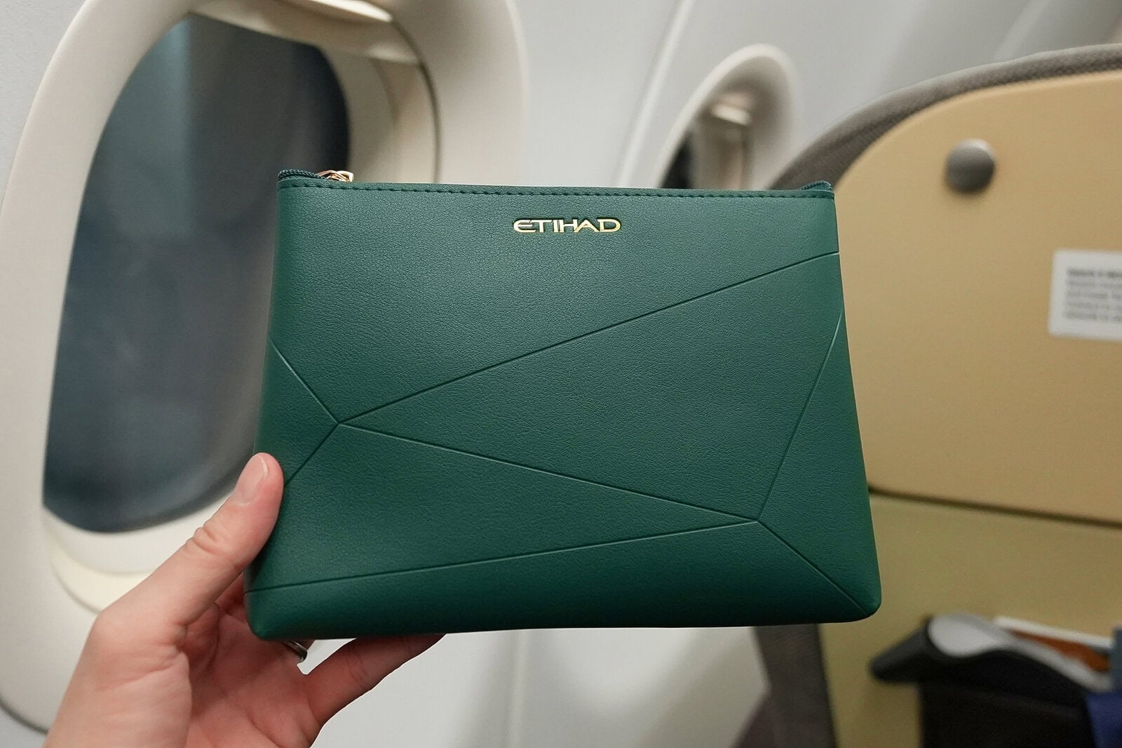 エティハド航空ビジネスクラスのグリーンのアメニティポーチとゴールドのETIHADロゴ
