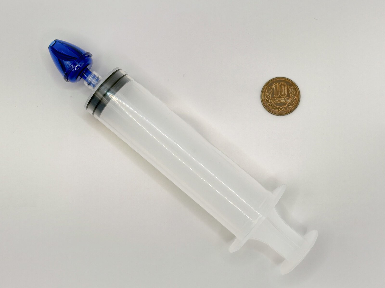 Ezy Doseのスリムな注射器型鼻うがい器と10円玉のサイズ比較写真