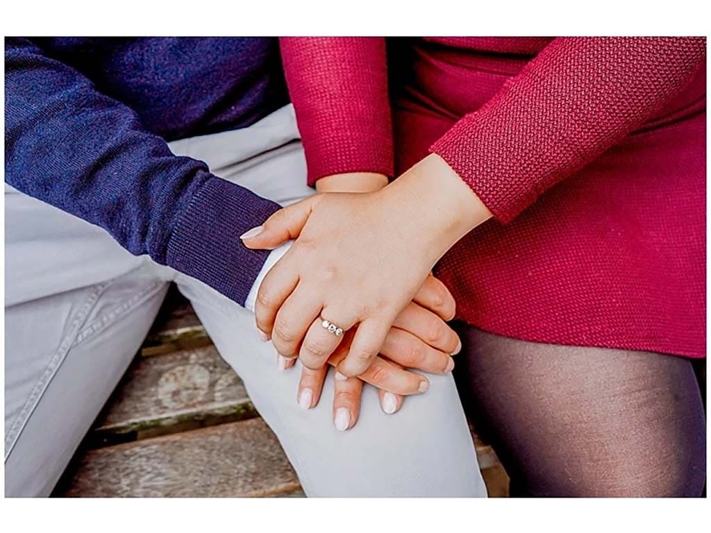 engaged couple hold hands