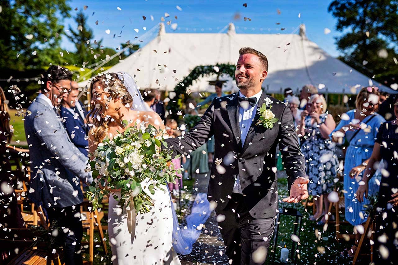 Bride and groom in a plume of confetti