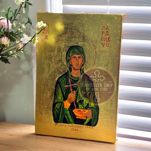 Custom handcrafted Orthodox icon of Saint Paraskevi on a wooden surface with white flowers on the side.
