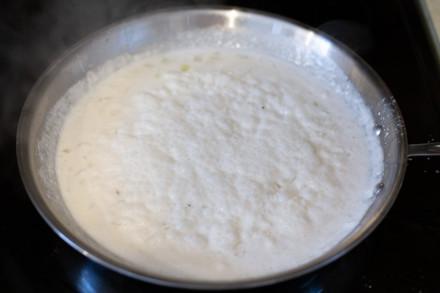 spinach artichoke sauce simmering in skillet