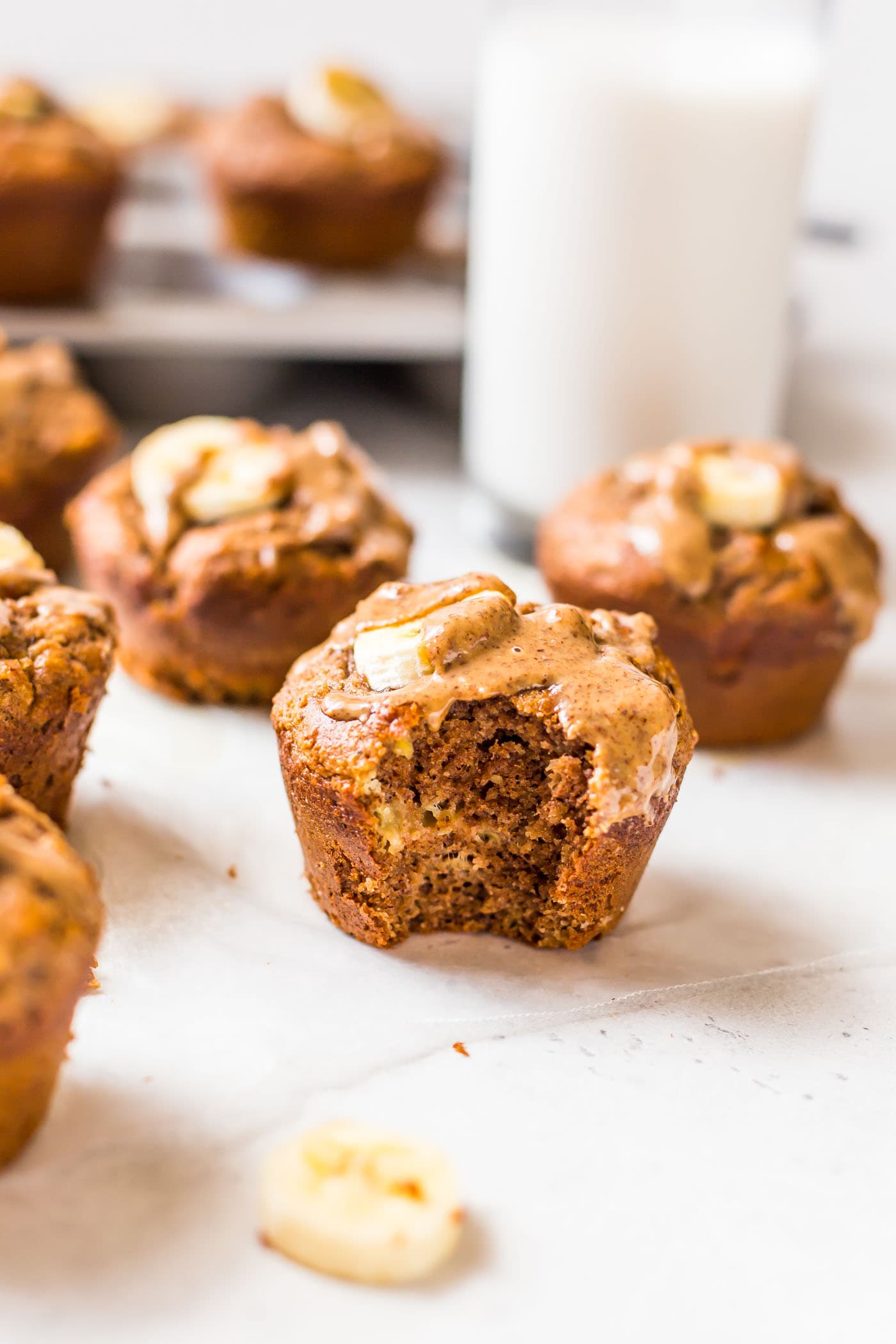 Baked Banana Protein Muffin with a bite bitten out of it on a white background
