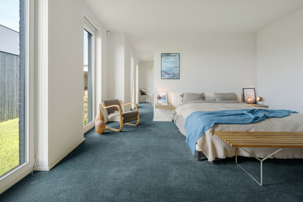 Schlafzimmer mit einem türkisfarbenen werkhaus Teppichboden. – KI bearbeitet