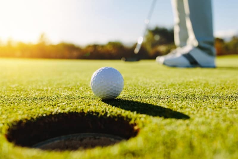 Man putting on green at golf course