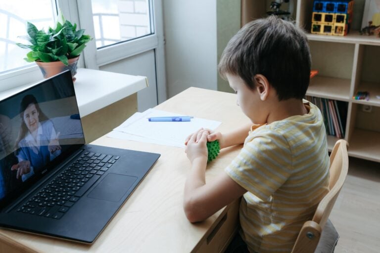 Child playing with toy, during a teletherapy session