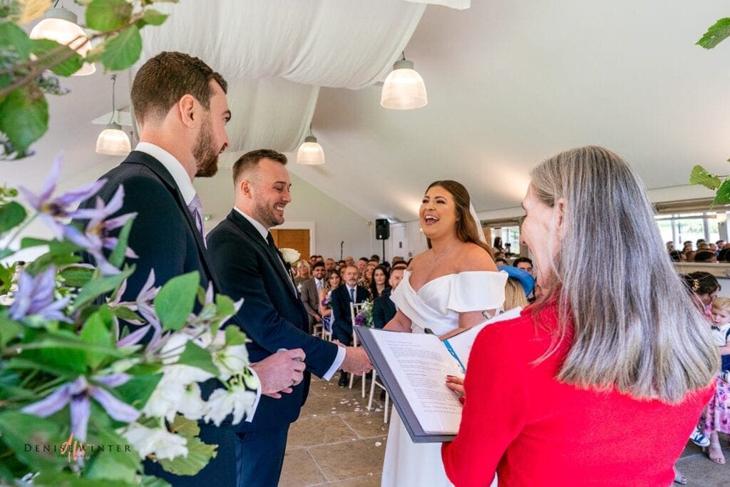Bride laughing as she exchanges wedding rings