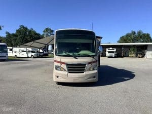 Front view of a Class A RV motorhome in an RV lot.