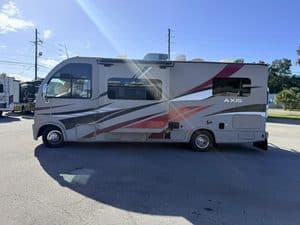Motorhome parked outdoors with clear sky and power lines in background.