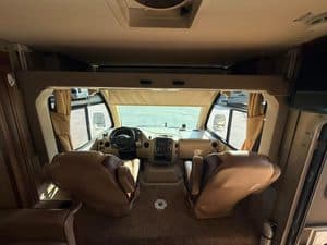 Luxury RV interior with driver and passenger seats and dashboard.