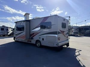 Modern travel trailer parked outdoors at RV dealership lot.