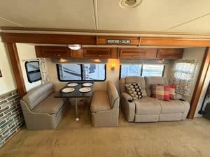 Comfortable RV interior with dining area and sofa for travel relaxation.