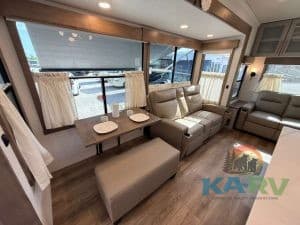 Comfortable RV living space with large windows and cozy seating.