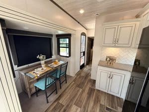Modern RV interior with dining area and kitchen in 2022 Keystone Cougar.