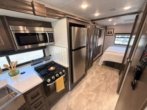 RV kitchen and bedroom interior in a 2023 Coachmen Mirada 35OS.