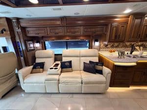 Luxury RV interior with cream sofa and wooden cabinetry in a 2016 Entegra Cornerstone 45B.