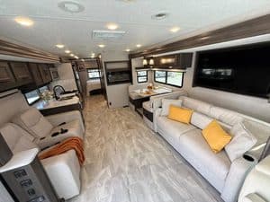 Spacious RV interior with sofa, dining area, and kitchen in a 2023 Coachmen Mirada 35OS.