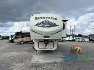RV trailer with Montana branding and mountain graphic, parked outdoors.